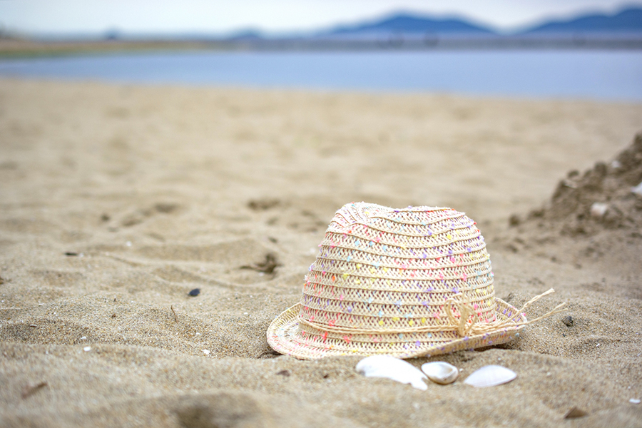 砂浜と麦わら帽子で夏の海のイメージ写真